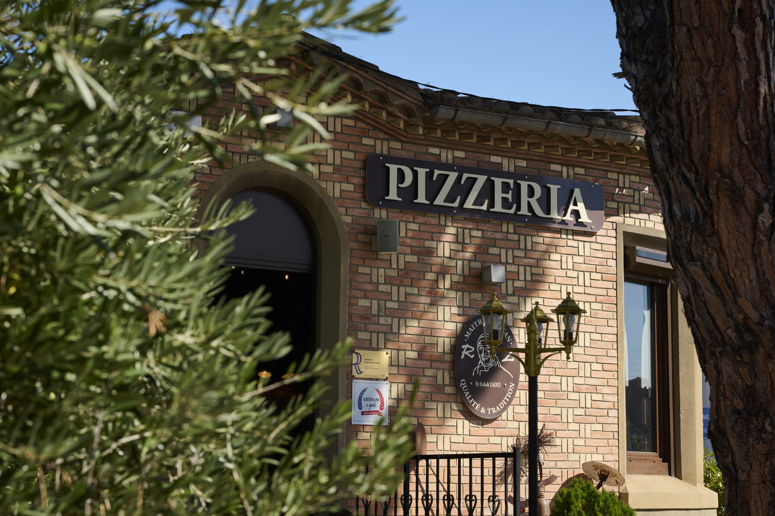 Entrée de la pizzeria du chef Rabah Zaoui, avec une ambiance accueillante et authentique.