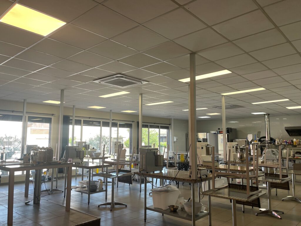 Salle de préparation de l'école de formation en pizza, avec postes individuels pour les étudiants.